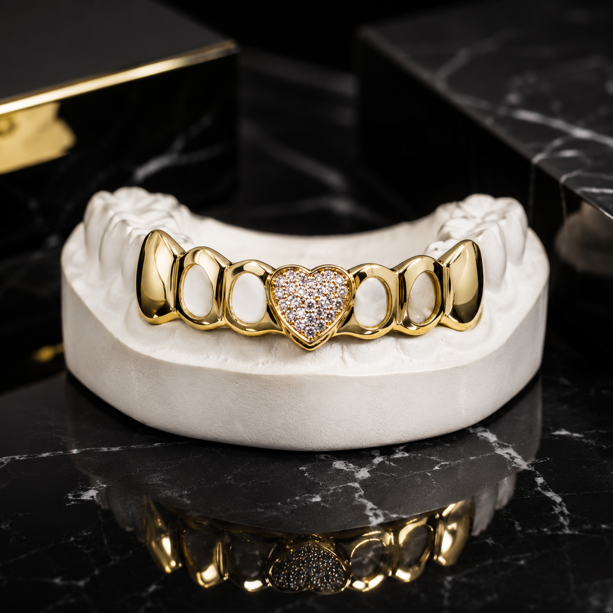 Custom Diamond Heart Open Face Bottom Grillz handcrafted in polished yellow gold with a pavé diamond heart centerpiece displayed on a white dental mold.