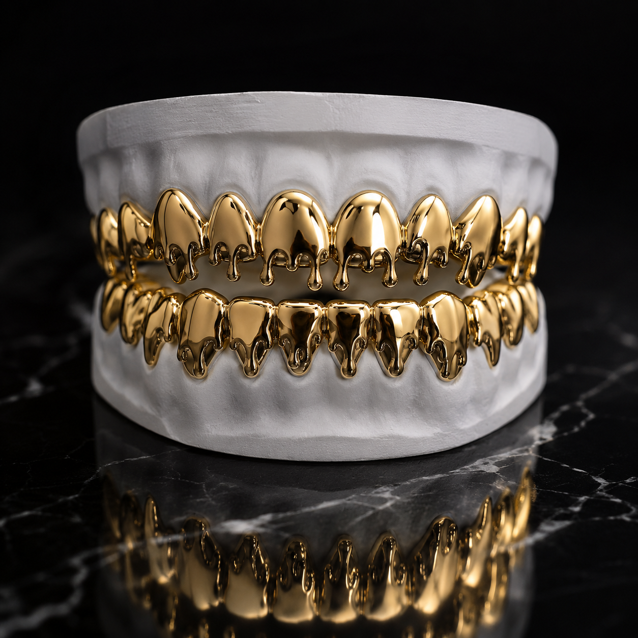 Custom handcrafted yellow gold Slime Grillz featuring flowing drip-inspired sculpted surfaces displayed on a white dental mold in a luxury jewelry studio.