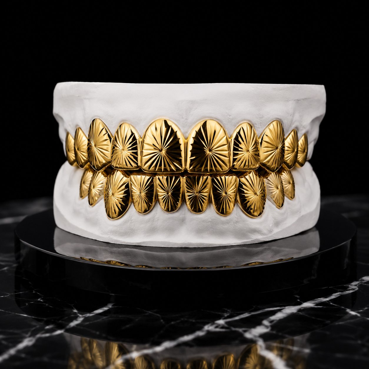 Custom Sunburst Mirror-Cut Gold Grillz handcrafted in solid yellow gold with precision engraved mirror finish displayed on a white dental mold against a luxury black marble background.